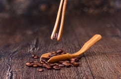 Coffee bean in wooden tweezers. Coffee beans in a wooden ladle. stock photos Coffee bean in wooden tweezers. Coffee beans in a wooden ladle. stock photos
