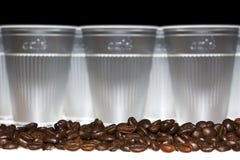 Coffee Beans In Front Of Plastic Cups Stock Images