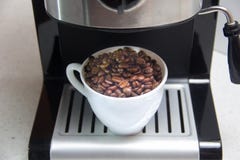 Coffee beans in a white Cup. Preparation of coffee. Coffee machine. stock photos Coffee beans in a white Cup. Preparation of coffee. Coffee machine. stock photos