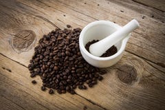 Coffee beans on wooden background and white mortar Stock Photo Coffee beans on wooden background and white mortar Stock Photo