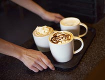 Coffee shopserver som levererar kaffe royaltyfri fotografi Coffee shopserver som levererar kaffe royaltyfri fotografi