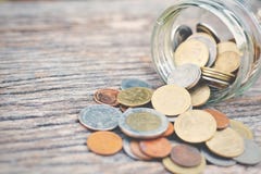 Coin in glass jar on old wood royalty free stock photo Coin in glass jar on old wood royalty free stock photo