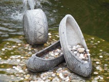 Coins in fountain with stone shoes stock photography Coins in fountain with stone shoes stock photography