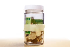 Coins in glass money jar savings with empty label, financial con royalty free stock photography Coins in glass money jar savings with empty label, financial con royalty free stock photography
