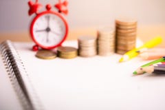 Coins stack and red alarm clock with Colored pencils on notebook. stock image Coins stack and red alarm clock with Colored pencils on notebook. stock image