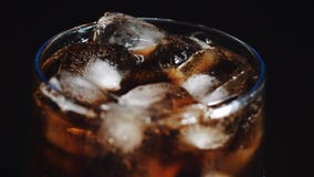 Cola och is i exponeringsglas, bubbla svävar upp lager videofilmer Cola och is i exponeringsglas, bubbla svävar upp lager videofilmer