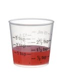 Cold or cough syrup medicine in a measuring cup isolated on whit Royalty Free Stock Images Cold or cough syrup medicine in a measuring cup isolated on whit Royalty Free Stock Images