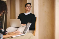 Colegas do negócio que trabalham em portáteis no escritório imagem de stock Colegas do negócio que trabalham em portáteis no escritório imagem de stock