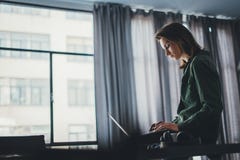 Collega femminile bello che si siede alla tavola e che per mezzo del computer portatile Lavoro trattato allo studio coworking pan immagini stock libere da diritti Collega femminile bello che si siede alla tavola e che per mezzo del computer portatile Lavoro trattato allo studio coworking pan immagini stock libere da diritti