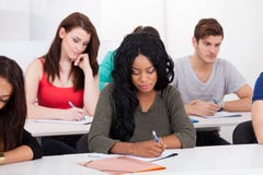 College Students Writing At Desk royalty free stock image College Students Writing At Desk royalty free stock image