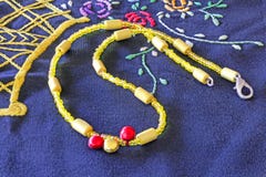 Collier jaune sur un napperon de main-emboikered de serviette photos libres de droits Collier jaune sur un napperon de main-emboikered de serviette photos libres de droits