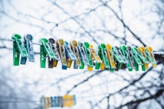 Colored clothespins on the clothesline are covered with frost in winter stock photos Colored clothespins on the clothesline are covered with frost in winter stock photos