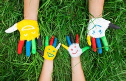 Colored Hands With Smile Painted In Colorful Paints Against Green Summer Background. Lifestyle Concept Royalty Free Stock Images