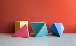 Colorful abstract geometrical composition. Three-dimensional prism pyramid tetrahedron rectangular cube objects on red stock photos Colorful abstract geometrical composition. Three-dimensional prism pyramid tetrahedron rectangular cube objects on red stock photos