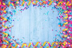 Colorful birthday or carnival frame with party items on wooden background.