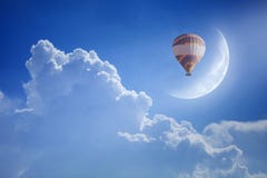Colorful hot air balloon rise up into blue sky above white cloud