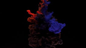 Colorful red and blue ink drops from above mixing in water, swirling softly underwater on black background stock footage Colorful red and blue ink drops from above mixing in water, swirling softly underwater on black background stock footage