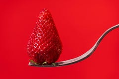 Red strawberry on fork with red display background stock photos Red strawberry on fork with red display background stock photos
