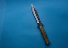 Coltello di caccia su un fondo monofonico blu coltello isolato immagini stock libere da diritti Coltello di caccia su un fondo monofonico blu coltello isolato immagini stock libere da diritti