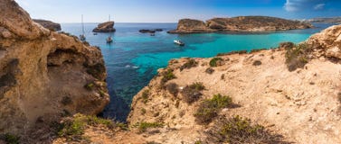 Comino, Malta - The beautiful Blue Lagoon with turquoise clear sea water, yachts and snorkeling tourists Royalty Free Stock Image Comino, Malta - The beautiful Blue Lagoon with turquoise clear sea water, yachts and snorkeling tourists Royalty Free Stock Image