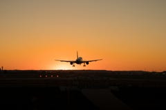 Commercial airplane is landing on the airport runway during sunset royalty free stock photography Commercial airplane is landing on the airport runway during sunset royalty free stock photography