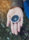 Compass lies on the hand of the girl. Direction of horizon