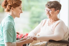 Compassionate nurse explaining a geriatric handicapped patient w