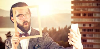 Composite image of businessman taking selfie while holding frame stock photography Composite image of businessman taking selfie while holding frame stock photography