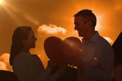 Composite image of smiling couple holding heart shape paper. Smiling couple holding heart shape paper against a cloudy sky Royalty Free Stock Photos Composite image of smiling couple holding heart shape paper. Smiling couple holding heart shape paper against a cloudy sky Royalty Free Stock Photos