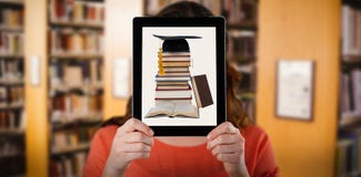 Composite image of woman holding digital tablet in front of her face stock photography Composite image of woman holding digital tablet in front of her face stock photography