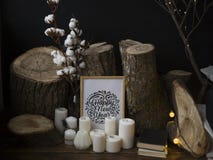 Composizione dagli abbattimenti degli alberi contro un fondo scuro, stanti su un pavimento di legno insieme alle candele e ad un' fotografie stock Composizione dagli abbattimenti degli alberi contro un fondo scuro, stanti su un pavimento di legno insieme alle candele e ad un' fotografie stock