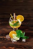 Composição colorida de um cocktail extravagante Citrinas cortadas e um vidro completo do álcool frio em um fundo da tabela fotografia de stock royalty free Composição colorida de um cocktail extravagante Citrinas cortadas e um vidro completo do álcool frio em um fundo da tabela fotografia de stock royalty free