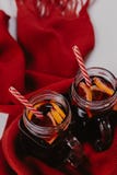 Composição decorada das canecas com vinho ferventado com especiarias no lenço feito malha, fim acima foto de stock royalty free Composição decorada das canecas com vinho ferventado com especiarias no lenço feito malha, fim acima foto de stock royalty free