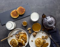 Composição do café da manhã com panquecas, leite e chá no fundo preto foto de stock Composição do café da manhã com panquecas, leite e chá no fundo preto foto de stock