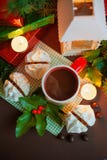 Composição festiva do Natal - uma caneca com Santa Klais, os bolos, as velas, os ramos do azevinho, as bagas e os presentes das c imagens de stock Composição festiva do Natal - uma caneca com Santa Klais, os bolos, as velas, os ramos do azevinho, as bagas e os presentes das c imagens de stock