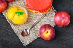 Composta della pesca con le mezze pesche in barattoli di vetro su una vecchia tavola di legno nera fotografia stock libera da diritti Composta della pesca con le mezze pesche in barattoli di vetro su una vecchia tavola di legno nera fotografia stock libera da diritti