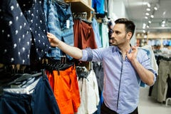 Compras hermosas del hombre para la ropa fotografía de archivo libre de regalías Compras hermosas del hombre para la ropa fotografía de archivo libre de regalías