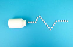 Compresse e una bottiglia per le medicine su un fondo blu Posto per la firma Il concetto di trattamento della malattia cardiaca fotografie stock Compresse e una bottiglia per le medicine su un fondo blu Posto per la firma Il concetto di trattamento della malattia cardiaca fotografie stock