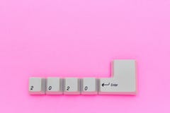Computer keyboard keys with 2020 enter written using the white buttons on pink background. New year technology concept royalty free stock photo Computer keyboard keys with 2020 enter written using the white buttons on pink background. New year technology concept royalty free stock photo