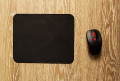 Computer mat and computer mouse on a wooden background, close-up, black computer mat royalty free stock image Computer mat and computer mouse on a wooden background, close-up, black computer mat royalty free stock image