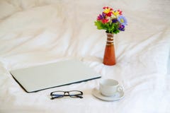 Computer portatile con i vetri e la tazza di caffè su fondo bianco immagini stock Computer portatile con i vetri e la tazza di caffè su fondo bianco immagini stock