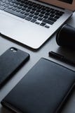 Computer portatile d'argento con il telefono nero, il taccuino nero e la penna nera con l'altoparlante, primo piano, vista superi fotografia stock libera da diritti Computer portatile d'argento con il telefono nero, il taccuino nero e la penna nera con l'altoparlante, primo piano, vista superi fotografia stock libera da diritti