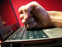 Computer problems 2. Conceptual shot for a computer cuasing trouble. A fist smashing it Computer problems 2. Conceptual shot for a computer cuasing trouble. A fist smashing it