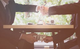 Conceito da corrupção feche acima do homem de negócios dois que agita as mãos e que recebe o dinheiro dos dólares Dinheiro do sub imagem de stock Conceito da corrupção feche acima do homem de negócios dois que agita as mãos e que recebe o dinheiro dos dólares Dinheiro do sub imagem de stock