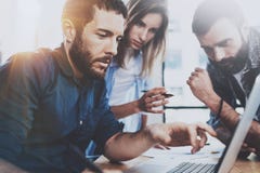Conceito da equipe do negócio Os profissionais novos que discutem o negócio novo projetam-se no escritório moderno O grupo de trê imagens de stock royalty free Conceito da equipe do negócio Os profissionais novos que discutem o negócio novo projetam-se no escritório moderno O grupo de trê imagens de stock royalty free