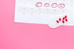 Conceito do ciclo da menstruação Calendário da menstruação com almofadas sanitárias e os comprimidos contraceptivos na opinião su imagem de stock Conceito do ciclo da menstruação Calendário da menstruação com almofadas sanitárias e os comprimidos contraceptivos na opinião su imagem de stock