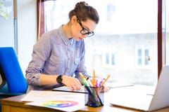 Concentrated woman fashion designer drawing sketches in office royalty free stock image Concentrated woman fashion designer drawing sketches in office royalty free stock image