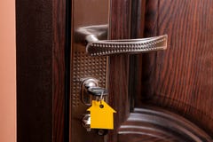 The concept of buying a home. Keys with keychain house in the door lock close-up stock image The concept of buying a home. Keys with keychain house in the door lock close-up stock image