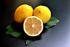 Concept d'un groupe de citrons, deux entiers et un demi- sur le fond noir photographie stock Concept d'un groupe de citrons, deux entiers et un demi- sur le fond noir photographie stock