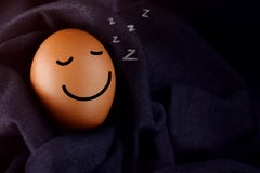 Concept de confort et de relaxation, oeuf heureux dormant avec le smiley F image libre de droits Concept de confort et de relaxation, oeuf heureux dormant avec le smiley F image libre de droits